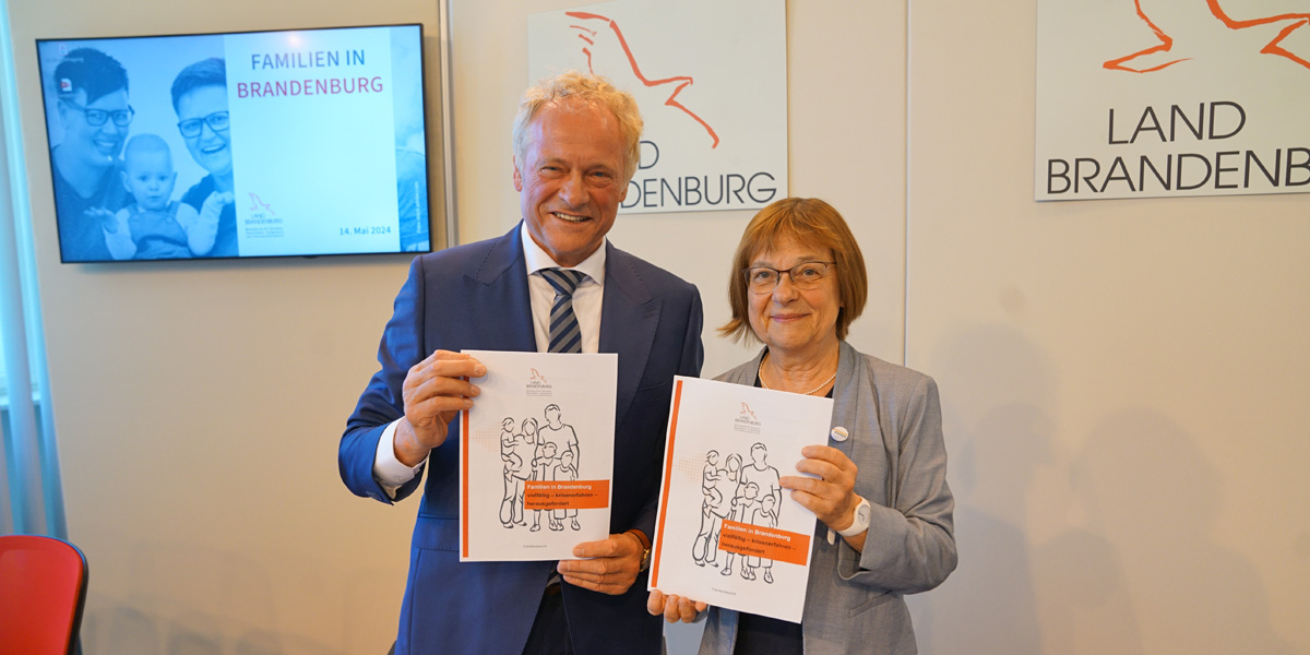 Prof. Dr. Dietmar Sturzbecher und Ministerin Ursula Nonnemacher halten die Exemplare des Familienberichtes in den Händen