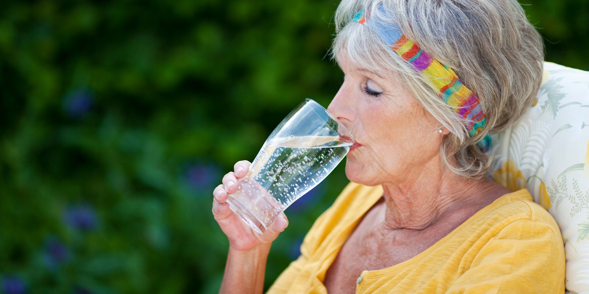 Eine Seniorin trinkt Wasser aus einem Glas, Foto: © contrastwerkstatt / Fotolia