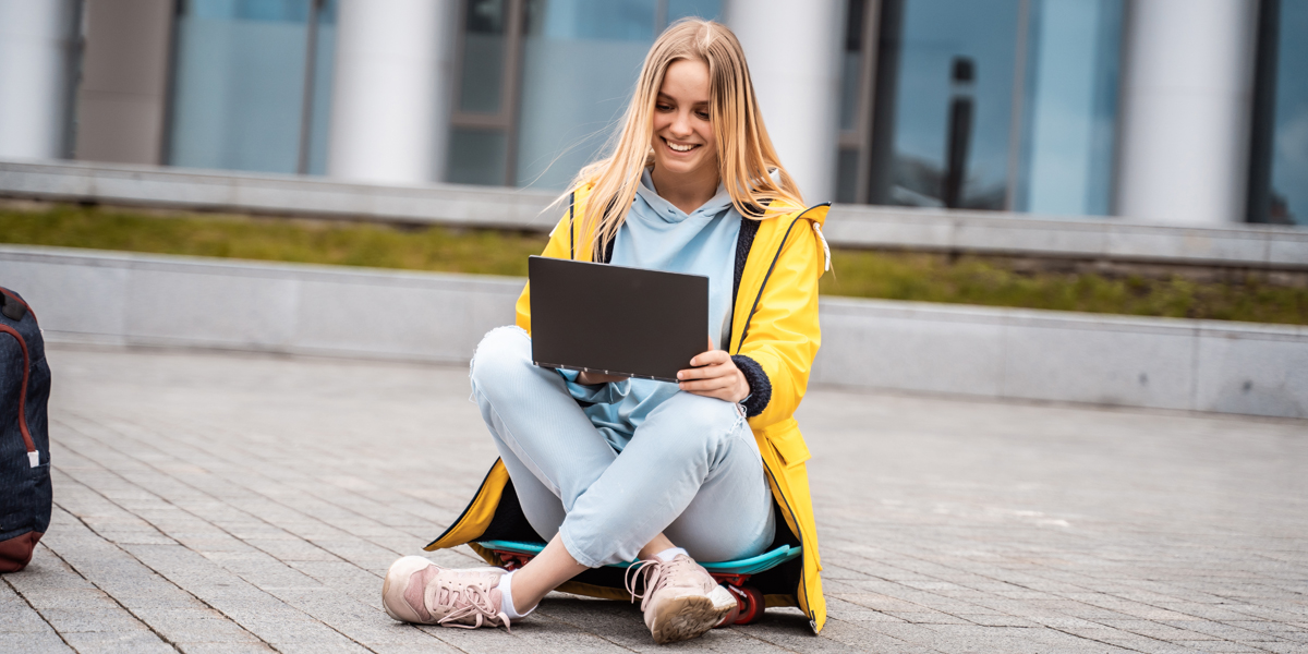 Symbolfoto Eine junge Frau sitzt auf dem Boden und schaut auf einem Laptop (Modell Foto: Colourbox.de / Tekso)