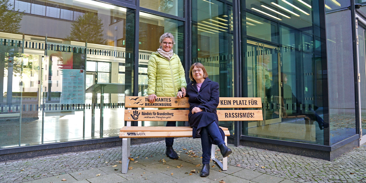 Staatssekretärin Antje Töpfer und Ministerin Ursula Nonnemacher mit der "Bank gegen Rassismus!" vor dem Ministerium.