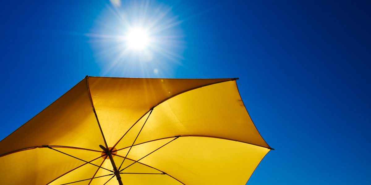 Gelber Sonnenschirm mit strahlend heller Sonne und blauem Himmel, Foto: © grafxart / Fotolia