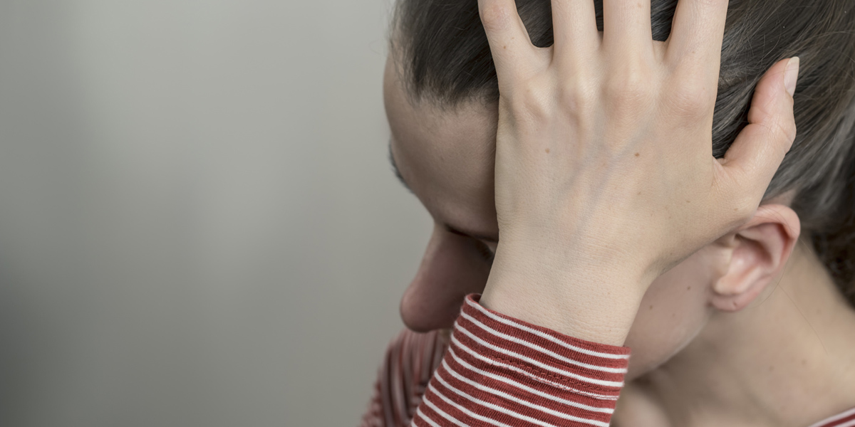 Eine traurige Frau fässt sich an den Kopf, Foto: © Oleksandr / Fotolia