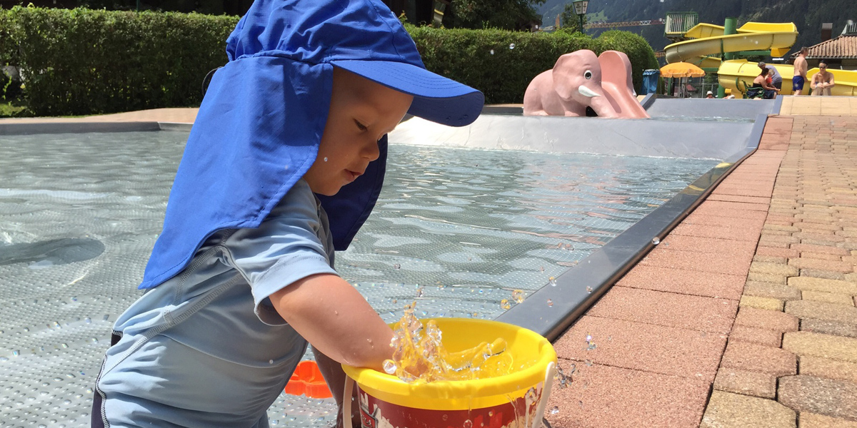 Kind im Schwimmbecken mit Sonnenschutz-Bekleidung, Foto: © Henry Czauderna / Fotolia